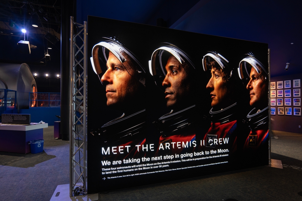 A poster showing the crew of the Artemis II mission, with photos of the astronauts and a caption reading MEET THE ARTEMIS II CREW