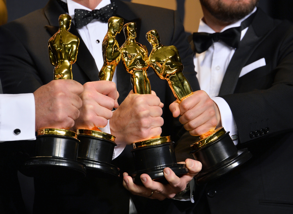 Oscar winners hold their trophies