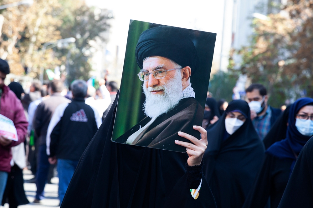 Woman holding picture of Ayatollah Ali Khamenei